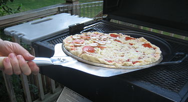 Slide pizza onto grill with aluminum peel