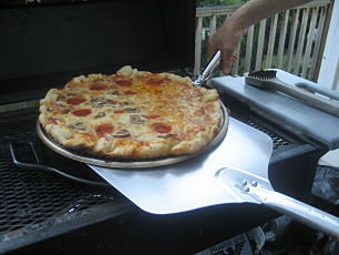 aluminum peel removes pizza on pizza disk from grill